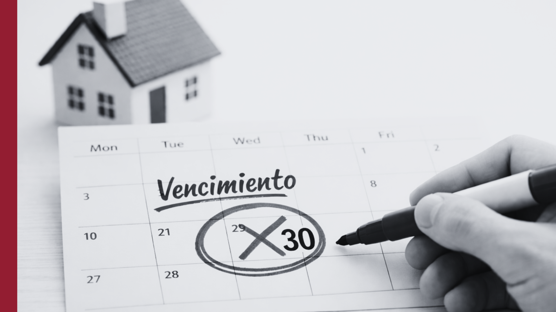 Calendario con la fecha de vencimiento del seguro de hogar marcada en rojo y una maqueta de casa al fondo